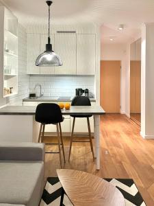 a kitchen and living room with a table and a couch at LUMI Apartament Mokotów in Warsaw
