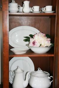 a shelf with plates and a bowl with flowers in it at Brekkafest in San Giuliano Terme