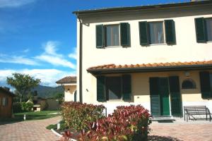 a white house with green shutters on it at Brekkafest in San Giuliano Terme