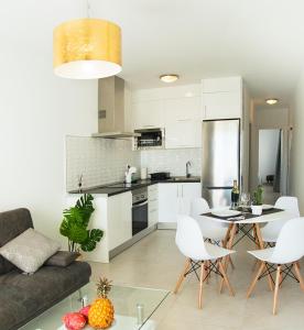 een keuken en een woonkamer met een tafel en stoelen bij Luxury Senator Apartments in Costa Teguise