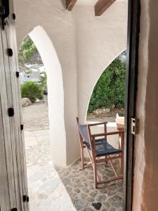 a table and a chair in a room with an archway at Binivell Park - Caliu apartments in Binibeca
