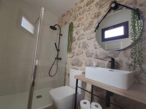 a bathroom with a sink and a shower and a mirror at Apartamento rural "El Albarelo" in Belmonte