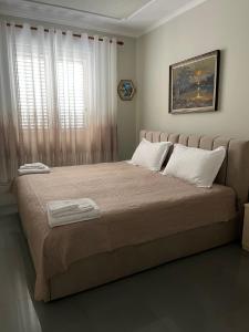 a bedroom with a large bed with two towels on it at Central Park Rooms in Tirana