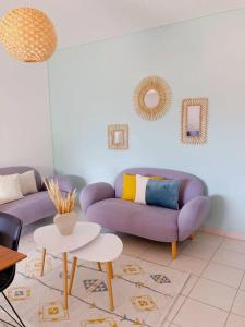 uma sala de estar com um sofá roxo e uma mesa em Appartement T3 chic et cosy em Caiena
