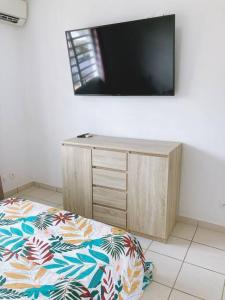 um quarto com uma cama e uma televisão na parede em Appartement T3 chic et cosy em Caiena