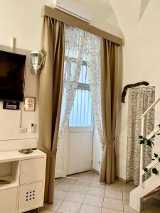 a large window with curtains in a room at Ursino holiday apartment in Catania