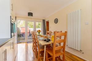 a kitchen and dining room with a table and chairs at Raymond James Accommodation, sleeps up to 7, free parking, full amenities and garden in Peterborough