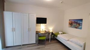 a bedroom with a bed and a desk with a computer at Zimmervermietung38 - Wild 3 in Salzgitter