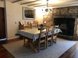 a dining room with a table and chairs and a fireplace at The Old Farmhouse at Mena in Bodmin