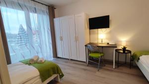 1 dormitorio con cama, escritorio y ventana en Zimmervermietung38 - Wild 3, en Salzgitter
