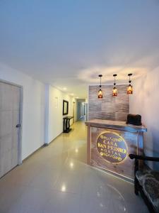 een hal met een tafel en verlichting aan een muur bij Hostal Casa San Pedro in Santa Marta