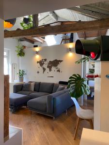 salon z niebieską kanapą i mapą świata na ścianie w obiekcie TOURinTURIN appartamento in Torino centro w Turynie