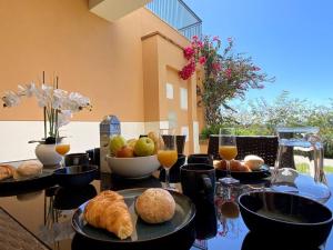 een tafel met borden en glazen sinaasappelsap bij Flor da Primavera by CORAL in Mexilhoeira Grande