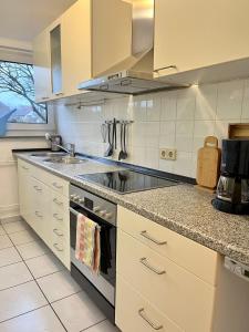 een keuken met een wastafel en een fornuis top oven bij Ferienwohnung mit Fernblick in Hagen