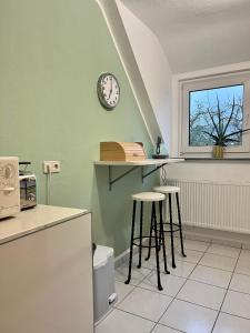 een keuken met krukken en een klok aan de muur bij Ferienwohnung mit Fernblick in Hagen
