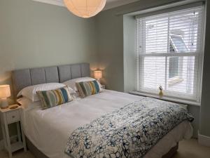 a bedroom with a bed and a window at Spacious, seaside, Victorian home "Bay View Terrace", Penzance in Penzance