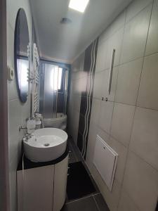 ein weißes Badezimmer mit einem Waschbecken und einem Spiegel in der Unterkunft Gogo Apartments in Ohrid