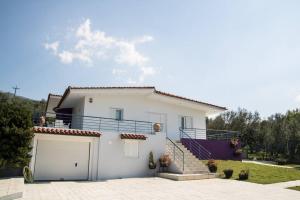 ein weißes Haus mit einer Garage und einer Treppe in der Unterkunft Olga's country house in Kalamata