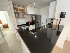 a kitchen with a black counter top and a phone at Apartamento en Arenas del Mar, Punta del Este in Punta del Este