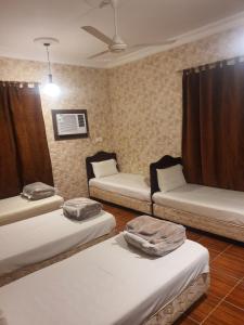 Cette chambre comprend 3 lits. dans l'établissement Villa Ar Rayis Beach, à Rayyis