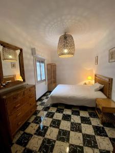 1 dormitorio con cama, tocador y espejo en La Casita Burriana en Burriana