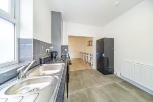 una cucina con 2 lavandini e un frigorifero di Hosted By Ryan - Huge 5 Bedroom House a Liverpool