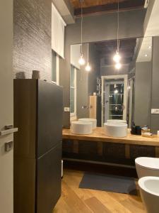 a large bathroom with two sinks and two mirrors at TOURinTURIN appartamento in Torino centro in Turin