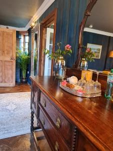 een houten dressoir met een spiegel erop bij Glencruitten House in Oban