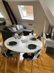 - une table et des chaises blanches dans le salon dans l'établissement Coeur de bouchon, à Troyes