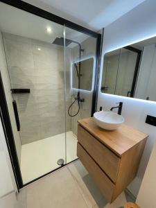 een badkamer met een wastafel en een glazen douche bij Gite de Clermont in Thimister