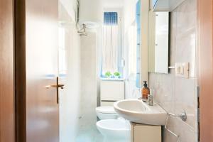bagno bianco con lavandino e servizi igienici di [Milan sweet home] Metro, Linate e Sky studio a Milano