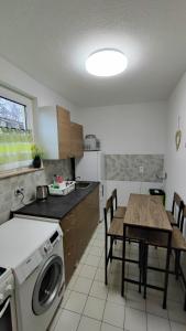 a kitchen with a table and a washing machine at Zimmervermietung38 - Nebel in Salzgitter