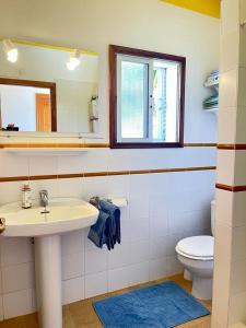 łazienka z umywalką, toaletą i lustrem w obiekcie Casa Mira, Ruhiger Bungalow in Las Norias w mieście Los Llanos de Aridane