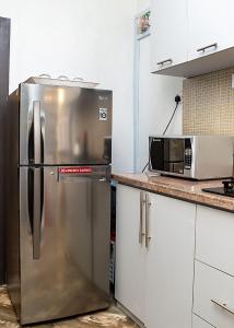 uma cozinha com um frigorífico e um micro-ondas em Palm Heights Apartments - Omole Phase 1, Ikeja em Ikeja