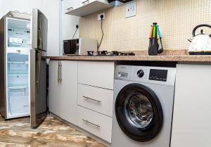 uma cozinha com uma máquina de lavar roupa e um frigorífico em Palm Heights Apartments - Omole Phase 1, Ikeja em Ikeja