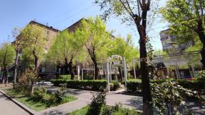 ein Park mit Bäumen und Sträuchern vor den Gebäuden in der Unterkunft Apartaments on Komitas 20 in Yerevan