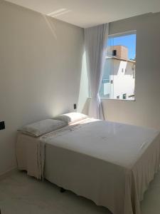 a bed in a bedroom with a window at ILHA in Itaparica Town