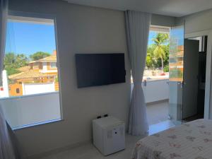 a bedroom with a flat screen tv and a bed at ILHA in Itaparica