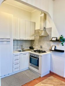 een keuken met witte kasten en een kookplaat oven bij Barco Guest House in Florence