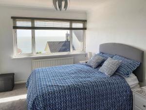 Seacliff في شانكلين: غرفة نوم بسرير لحاف ازرق ونافذة