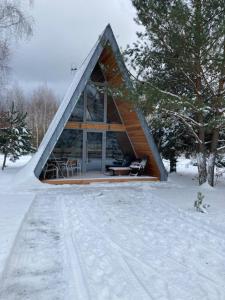 ein kleines Haus im Schnee im Wald in der Unterkunft Świronek in Białowieża