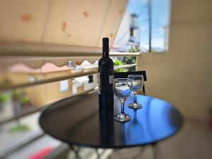 a bottle of wine and two glasses on a table at Volos Studio Stella in Volos