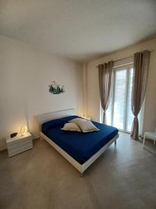 a bedroom with a blue bed and a window at Casa Lerici Holidays in Lerici