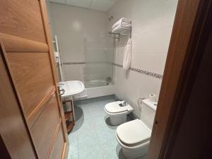 een kleine badkamer met 2 toiletten en een wastafel bij Hostal Villa el Colmenar in Mombeltrán