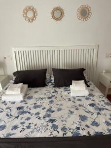 een slaapkamer met een blauw en wit bed met 2 kussens bij Carmen12 in Xàtiva