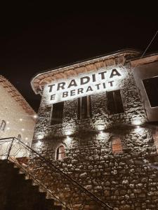 a sign on the side of a brick building with lights at Tradita e Beratit in Berat