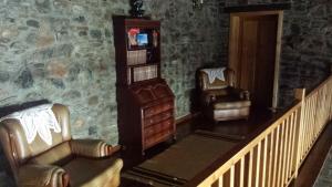 a living room with two chairs and a book shelf at Moleiro de Bacal in Baçal