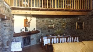 Baçal的住宿－Moleiro de Bacal，客厅配有桌子和石墙