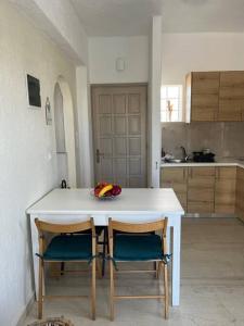 een keuken met een witte tafel en 2 stoelen bij Villa Rena in Istron