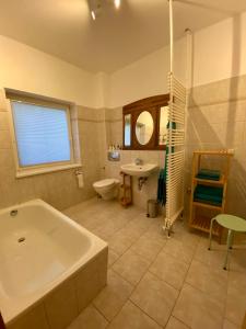 ein Badezimmer mit einer Badewanne, einem WC und einem Waschbecken in der Unterkunft Fewo am Theater mit Terrasse und Stellplatz in Stralsund